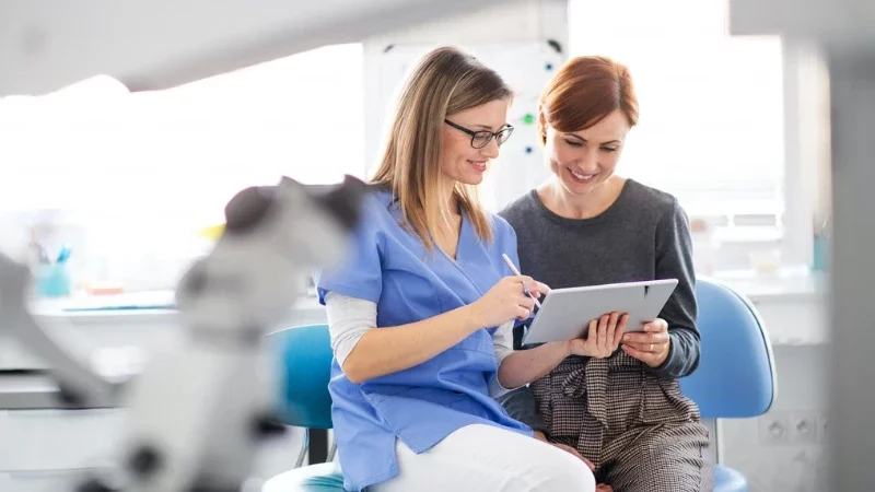1. Build a Patient-Centric Website doctor talking to his patient and showing tablet